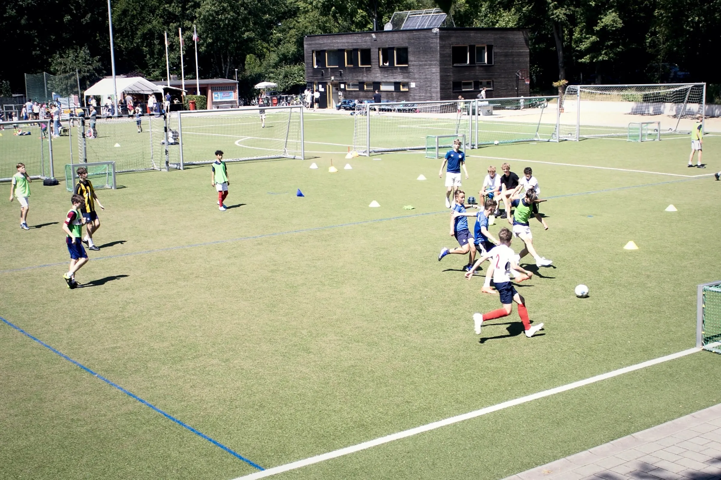 Jugendspieler beim Training auf dem Kunstrasenplatz im Quellental, im Hintergrund das Vereinsheim
