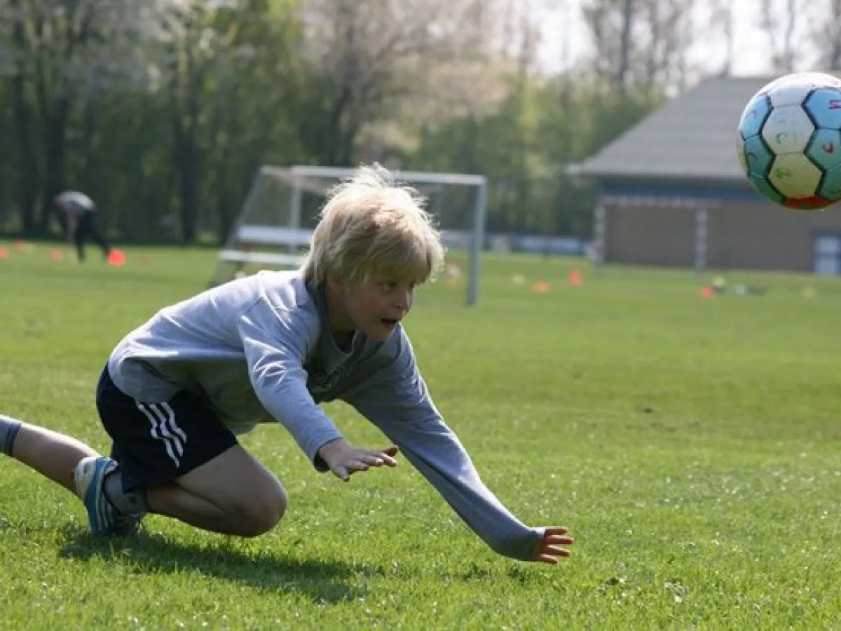 Junge hechtet beim Training nach dem Ball